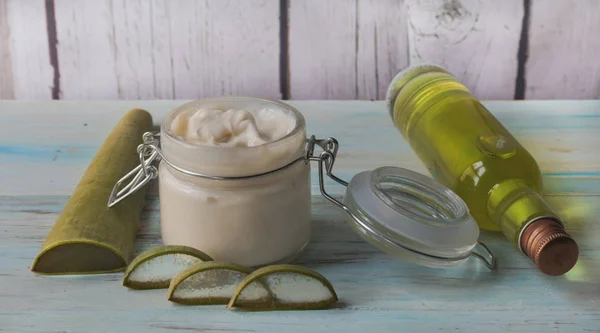 Crema de Aloe Vera casera en un frasco de vidrio, con hojas de aloe cortadas — Foto de Stock