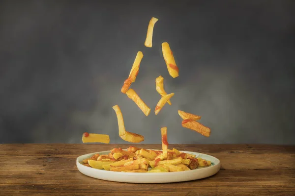 Bratkartoffeln mit Ketchup fliegen auf einem Keramikteller — Stockfoto