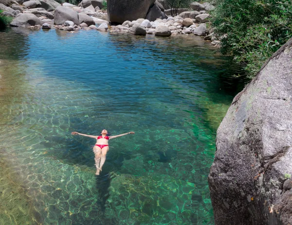 Mujer con bikini rojo flotando en un río —  Fotos de Stock