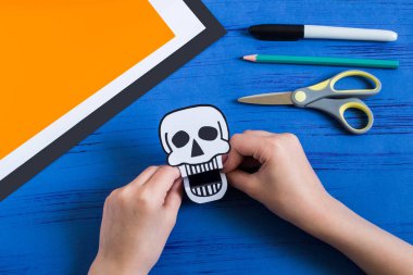 Çocuk dişlek kağıt oyuncaklar (kafatası ve Jack-o'-lantern) Cadılar Bayramı için yapar. Çocuk sanat projesi. DIY kavramı. Adım adım fotoğraf eğitimi. Adım 6. Kat bitmiş oyuncak kafatası 