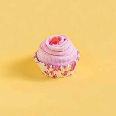 Fırın, imitasyon cupcakes için kağıt formunda çorap. Pembe kompozisyon sarı zemin üzerine. En az tarzı. Yaratıcı bir fikir, hayal ve fantezi. Festival Hediyelik konsepti