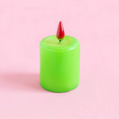 Pastel pembe arka plan yangın yerine acı biber ile mum. Minimalist tarzda, hayal ve fantezi. Baharat yanan yaratıcı fikir