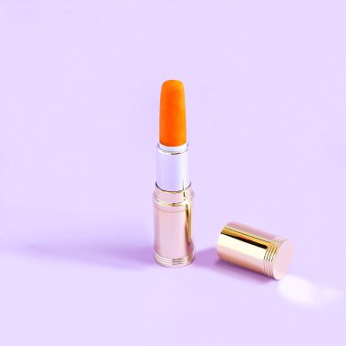 Pastel leylak arka plan ruj yerine havuç ile tüp. Minimalist tarzı. Renk ve şekil yaratıcı bir fikir. Gıda ve moda Tema fanteziler