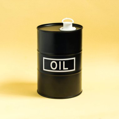 Küçük siyah varil petrol sarı arka plan ile. En az petrol iş kavramı