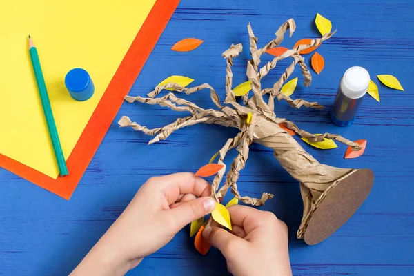 How to make together with child autumn tree from craft package. Original children's art project. DIY concept. Step-by-step photo instructions. Step 9. Glue leaves of tree