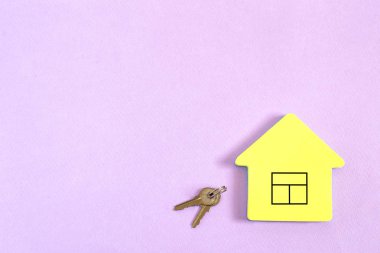 Sarı blok kağıt resmi penceresi ve pastel leylak arka tuşlar ile ev şeklinde notlar için. En az tarzı. Satış veya satınalma gayrimenkul kavramı. Kopya alanı