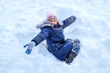Küçük şirin kız kış gününde eğleniyor. Çok kar vardır. Neşeli kız rüzgârla oluşan kar yığını içinde oturur ve kar atar