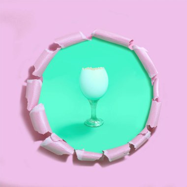 Cam olarak yumurta kabuğu. Doğal formu ile gerçek dışı nesnesi. Orijinal fikir, hayal ve fantezi. Yeşil arka plan delik ile lime lime pembe kağıt'ın altında. Yaratıcı en az Paskalya kavramı