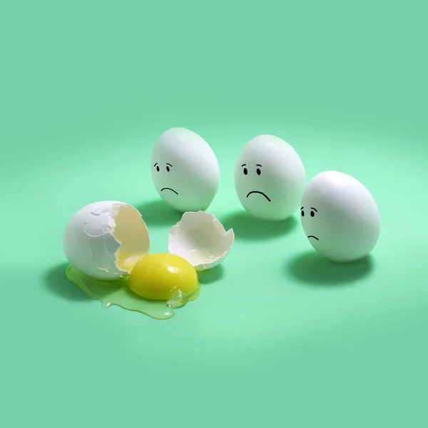 Three eggs with sad faces next to broken egg. Original idea, imagination and fantasy. Creative minimal concept