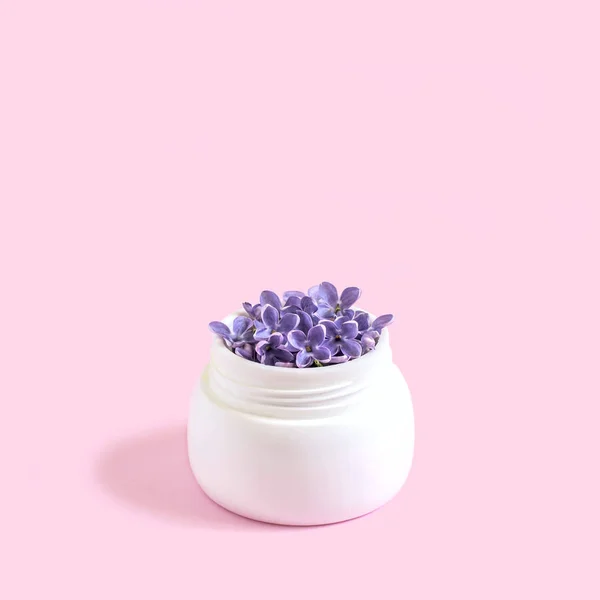 Frasco com flores de lilás como creme cosmético — Fotografia de Stock