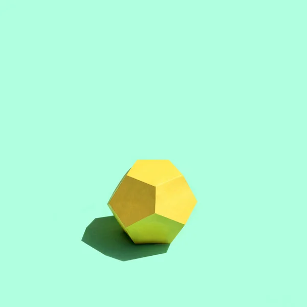 Papel amarelo dodecaedro na luz do sol brilhante — Fotografia de Stock