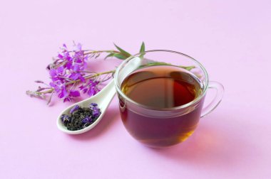 Useful herbal tea from fermented leaves fireweed on pink backgro clipart