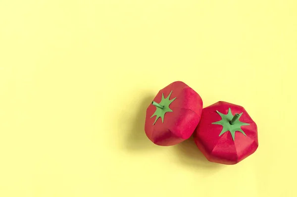 Sarı arka planda iki kağıt domates — Stok fotoğraf