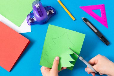 Çocuk Noel ağacından kart yapıyor. Orijinal çocuk sanat projesi. Diy konsepti. Adım adım fotoğraf talimatları. Dördüncü adım. Noel ağacını kes 