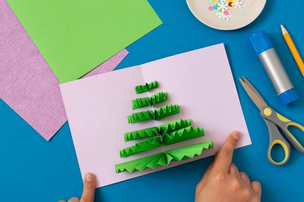 How to make Christmas card with volumetric tree. Original project for children. DIY concept. Step-by-step photo instructions. Step 8. Glue stripes on other half of card