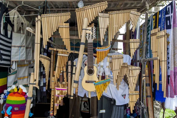 A variety of zamponas (pan flutes) and a guitar for sale at the market in Peguche in Ecuador. Music plays an important role in the lives of South Americans.