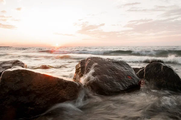 Морський пейзаж на заході сонця, море з камінням, літо — стокове фото