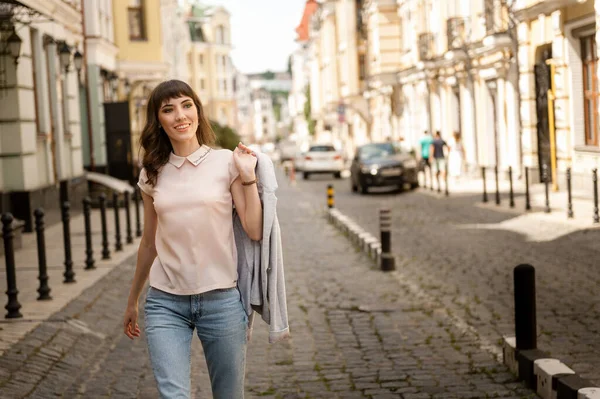 Girl walks around the city in the hands of a jacket drill — Stock Photo, Image