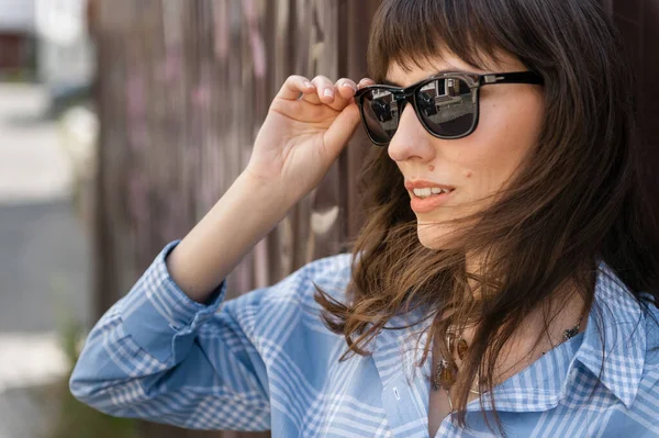 Portrait of a girl in sunglasses in the city against the backdrop of a painted wall — Stock Photo, Image