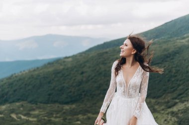 Gelin buketi fırlatmaya hazırlanıyor. Dağlarda gelin