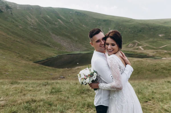 Gelin ve damat, altın tepede durarak birbirlerine nazikçe sarılıyorlar..