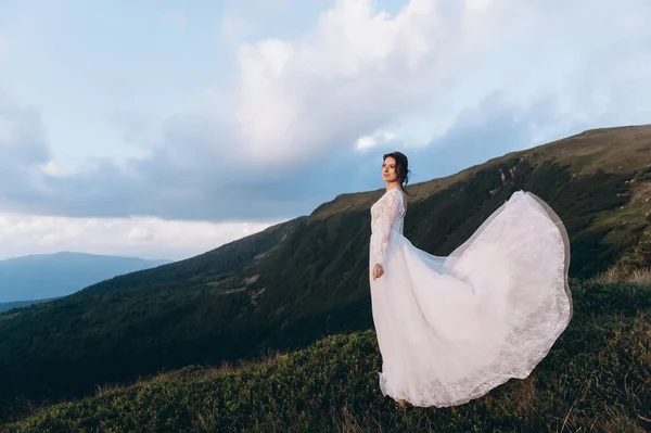 Gelini gezdir. Hafif ve havadar bir elbise rüzgarda dalgalanıyor..