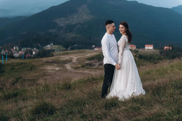 Manzaralı dağ manzarası. Genç ve güzel bir çift damat ve gelin dağda yürüyor.