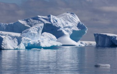 Travel along Antarctica on the scientific vessel. Studying of ices, sea inhabitants and global warming. Icebergs of various forms and colours. clipart