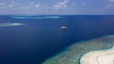 Tropikal adalar ve atolls. Dron--dan ateş. Okyanusun saf turkuaz suları. Beyaz mercan kum ve mavi lagün
