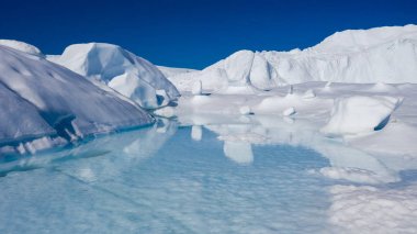 Buzdağları üzerinden uçuş ve kısa bir mesafeden uçların çekim. Çözünme izleri olan bir buzdağı yüzeyi. Küresel ısınma bir fenomen araştırma. Dünya Okyanusu 'nda yüzen buz ton milyonlarca