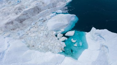 Buzdağları üzerinden uçuş ve kısa bir mesafeden uçların çekim. Çözünme izleri olan bir buzdağı yüzeyi. Küresel ısınma bir fenomen araştırma. Dünya Okyanusu 'nda yüzen buz ton milyonlarca
