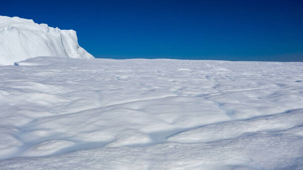 Полет над айсбергами и стрельба льдами на небольшом расстоянии. Поверхность айсберга с оттаивающими следами. Исследование феномена глобального потепления. Миллионы тонн плавающего льда в Мировом океане

