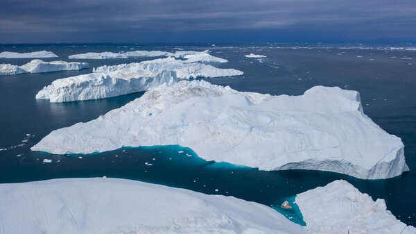 Flight over icebergs and shooting of ices at a short distance. An iceberg surface with thawing traces. Research of a phenomenon of global warming. Millions of tons of floating ice in the World Ocean