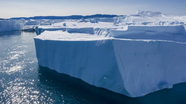 氷山の上を飛行し 短い距離で氷の撮影 解凍痕跡を持つ氷山の表面 地球温暖化現象の研究世界の海洋に浮かぶ氷の何百万トン — ストック写真