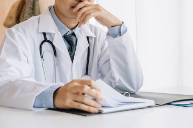 Asya erkek doktor oturma ve dolayısıyla için dinlenme The çene üzerinde onun el