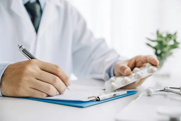 Close up hands doctor take pills, tablets and writing prescripti — Stock Photo, Image