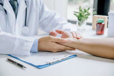 Doktor hastanın kan basıncını tıbbi odada kontrol ediyor.