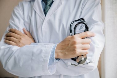 Doktorlar kollarla ayakta dikilip hastanede duruyordu. Fizici