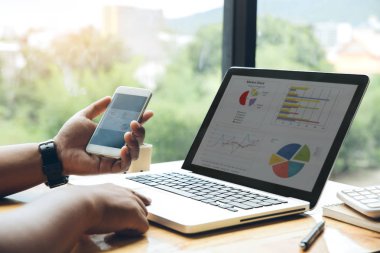 Adam ofisinde akıllı bir telefon ve dizüstü bilgisayar ile çalışıyor. Bu konuda 