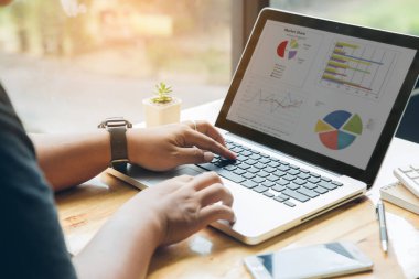 Adamın elleri ahşap masada oturan onun laptop üzerinde çalışıyor meşgul. 