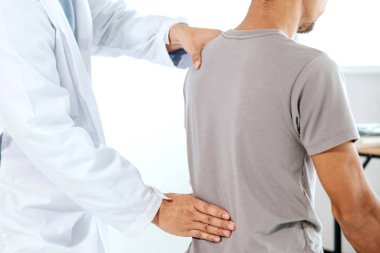 Fizyoterapist insan sırtında şifa tedavisi yapıyor. Sırt ağrısı 