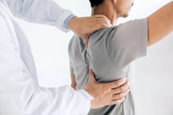 Physiotherapist doing healing treatment on man's back.Back pain