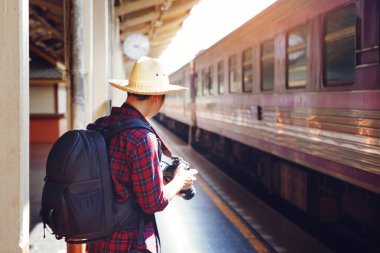Fotoğraf kamera ve sırt çantası ile Man Traveler demiryolu st standı