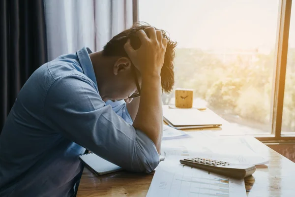 Stressed businessman.A young man sits at his Desk and holds his — Stock Photo, Image