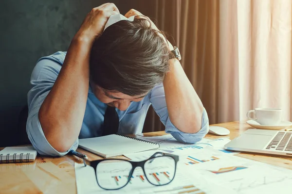 Stresszes üzletember. Egy fiatal férfi ül az ő Desk és birtokolja a — Stock Fotó