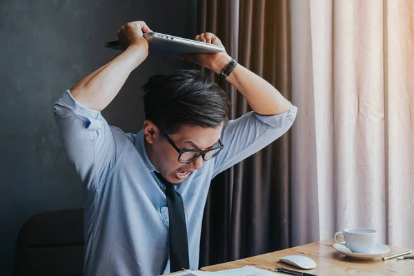 Angry businessman smashing his laptop because business is not as — Stock Photo, Image