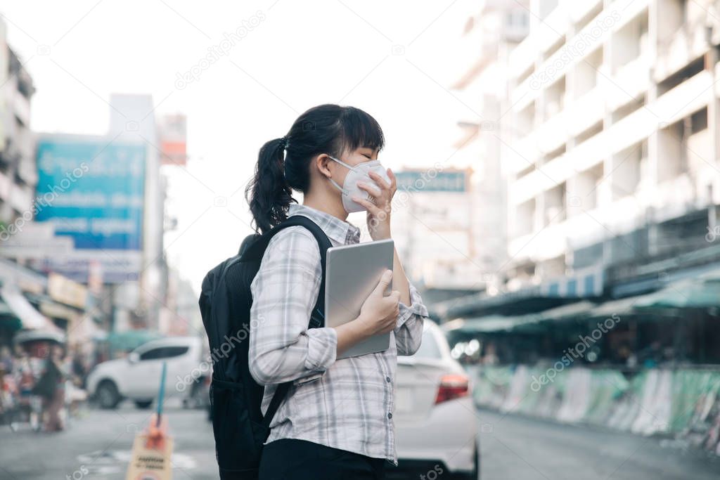 Asian woman wearing face mask coughing because of air pollution 