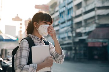 Şehirde hava kirliliği nedeniyle maskeli kadın