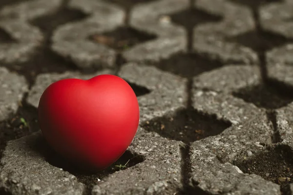 Красное сердце помещено на бетон. — стоковое фото