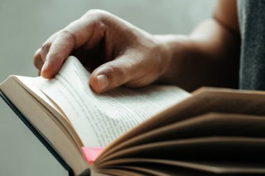 Adam ellerini kapat. Genç adam bir kitap açma ve okuma, 